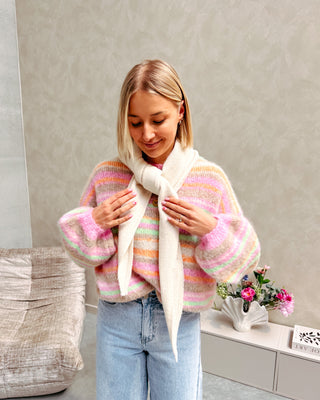Model draagt een trui met pastel kleurtjes en daarop een ecru driehoek sjaal.