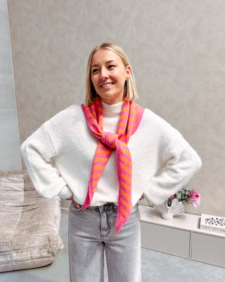 Model draagt een witte basic trui met daarop een driehoek sjaaltje met streepjes in felle kleurtjes, oranje en roze.